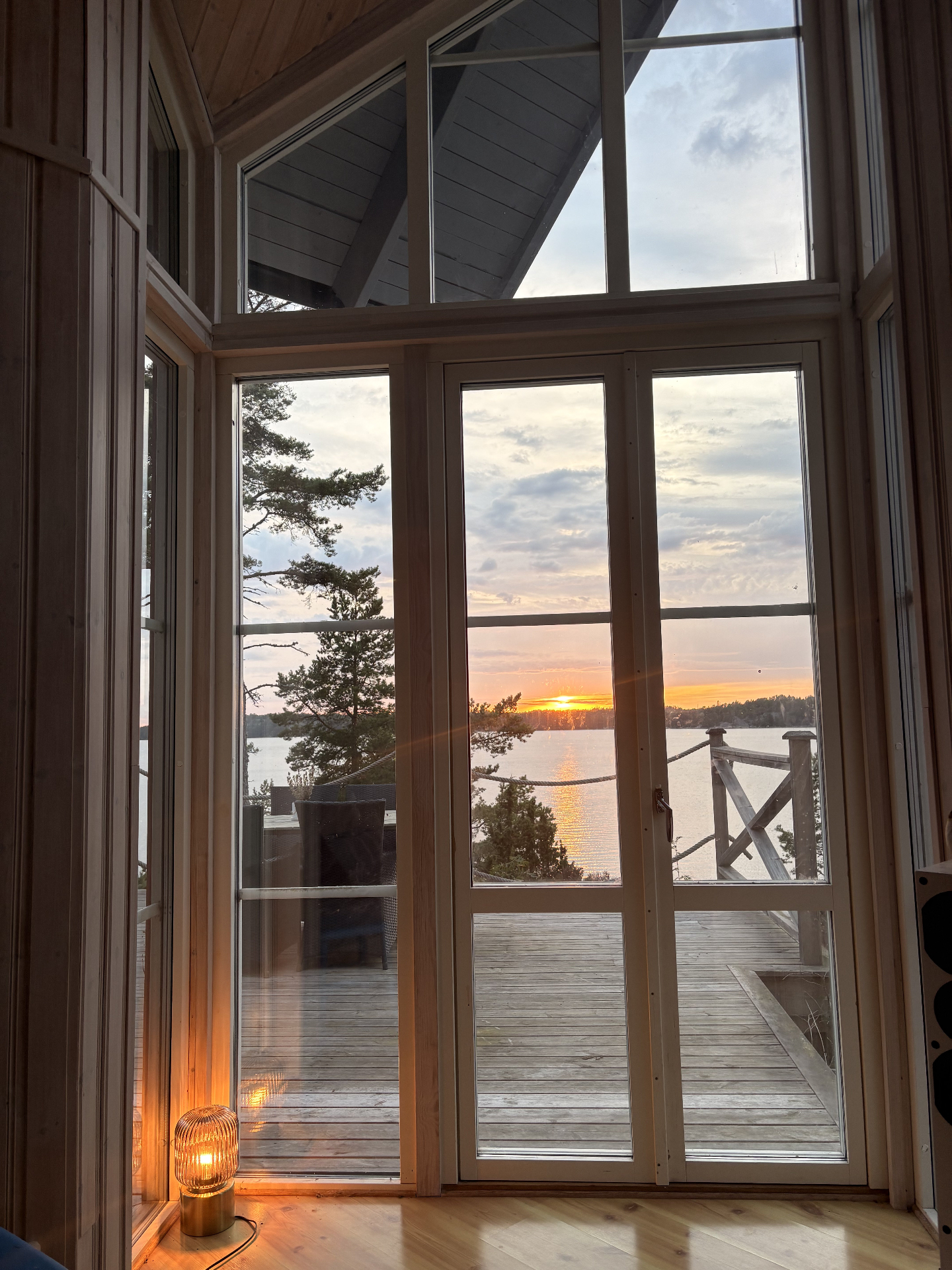 Höga altandörrar med skärgårdssolnedgång över altanen